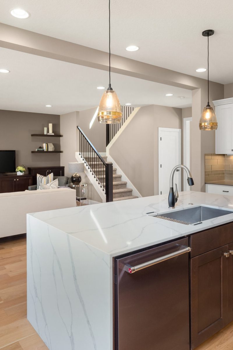 Kitchen and living room in new luxury home. Kitchen features wat
